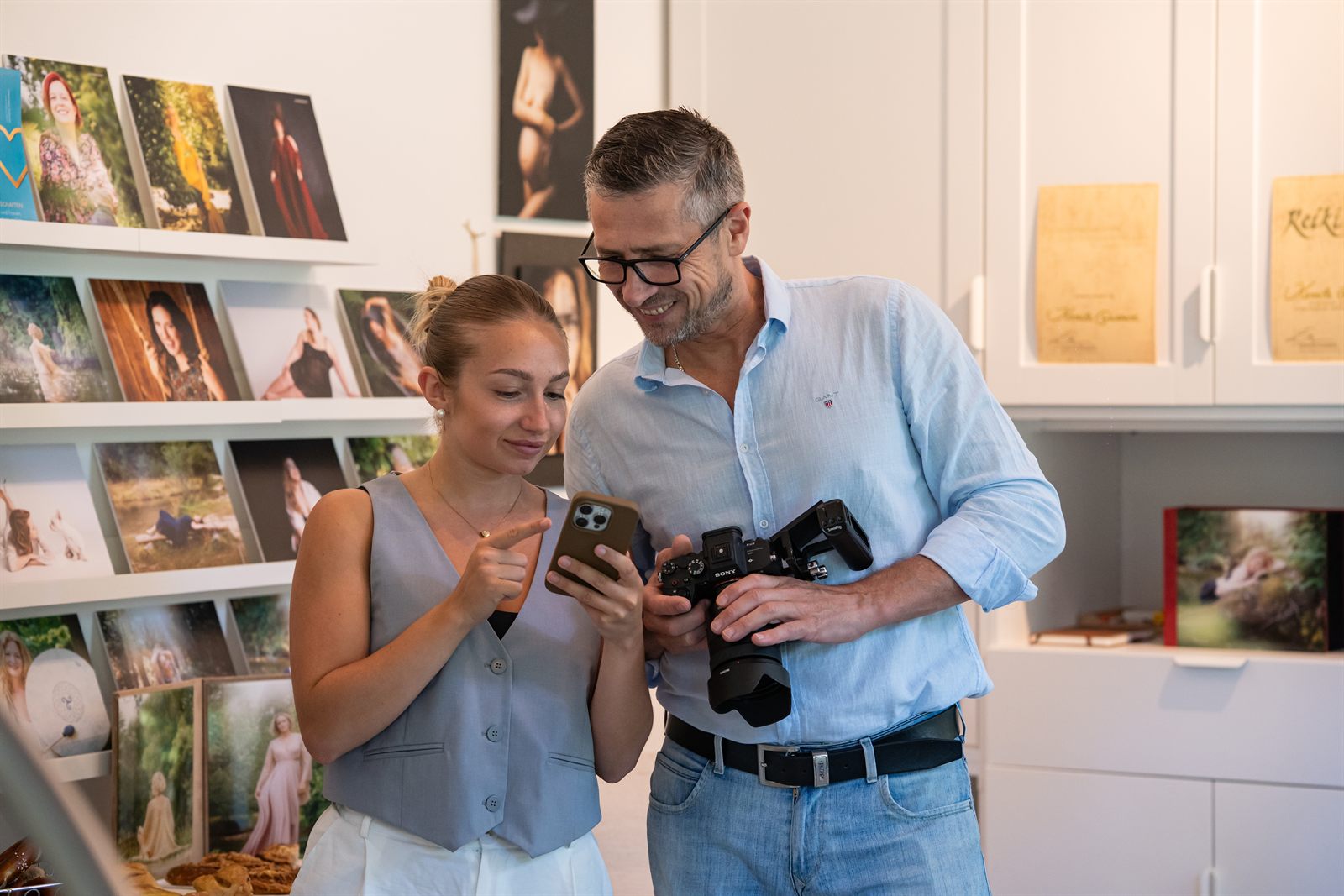 Viktor Obholz bespricht mit einer Fotografin Bilder auf dem Smartphone im Studio