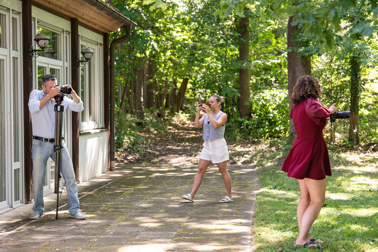 Fotograf beim Outdoor-Shooting, Assistentin dokumentiert die Aufnahme